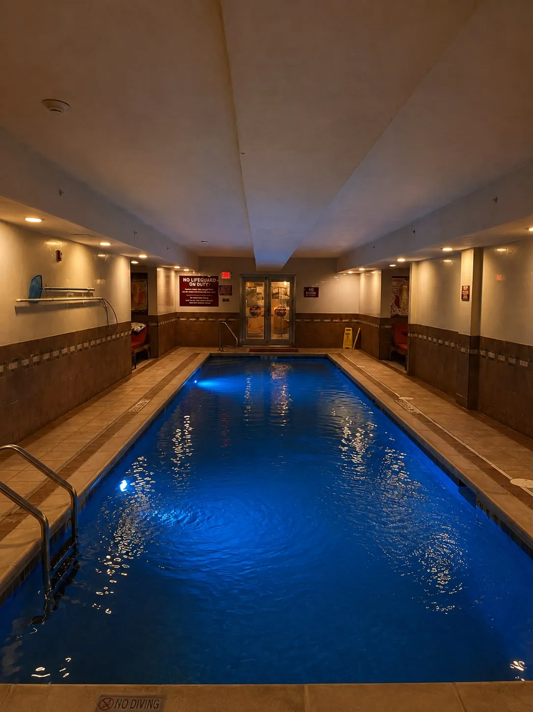 The length of the lap pool, lit blue, under a low white ceiling.
