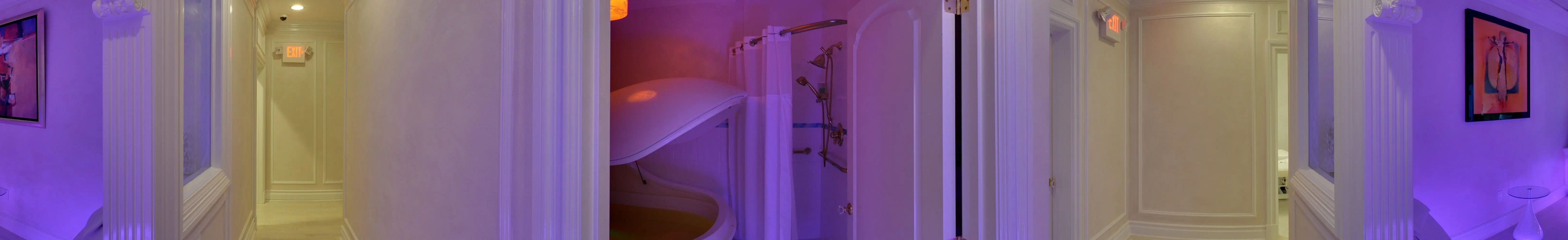 The float pod with its lid raised, in a violet-lit room beside a shower.