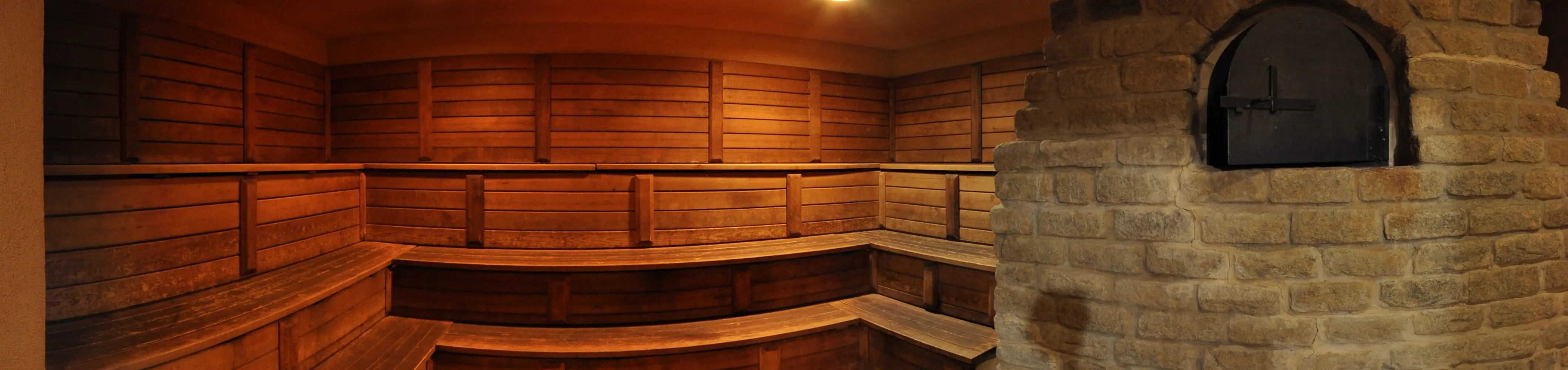 The tiered cedar benches of BRC's Russian dry sauna, lit warm.