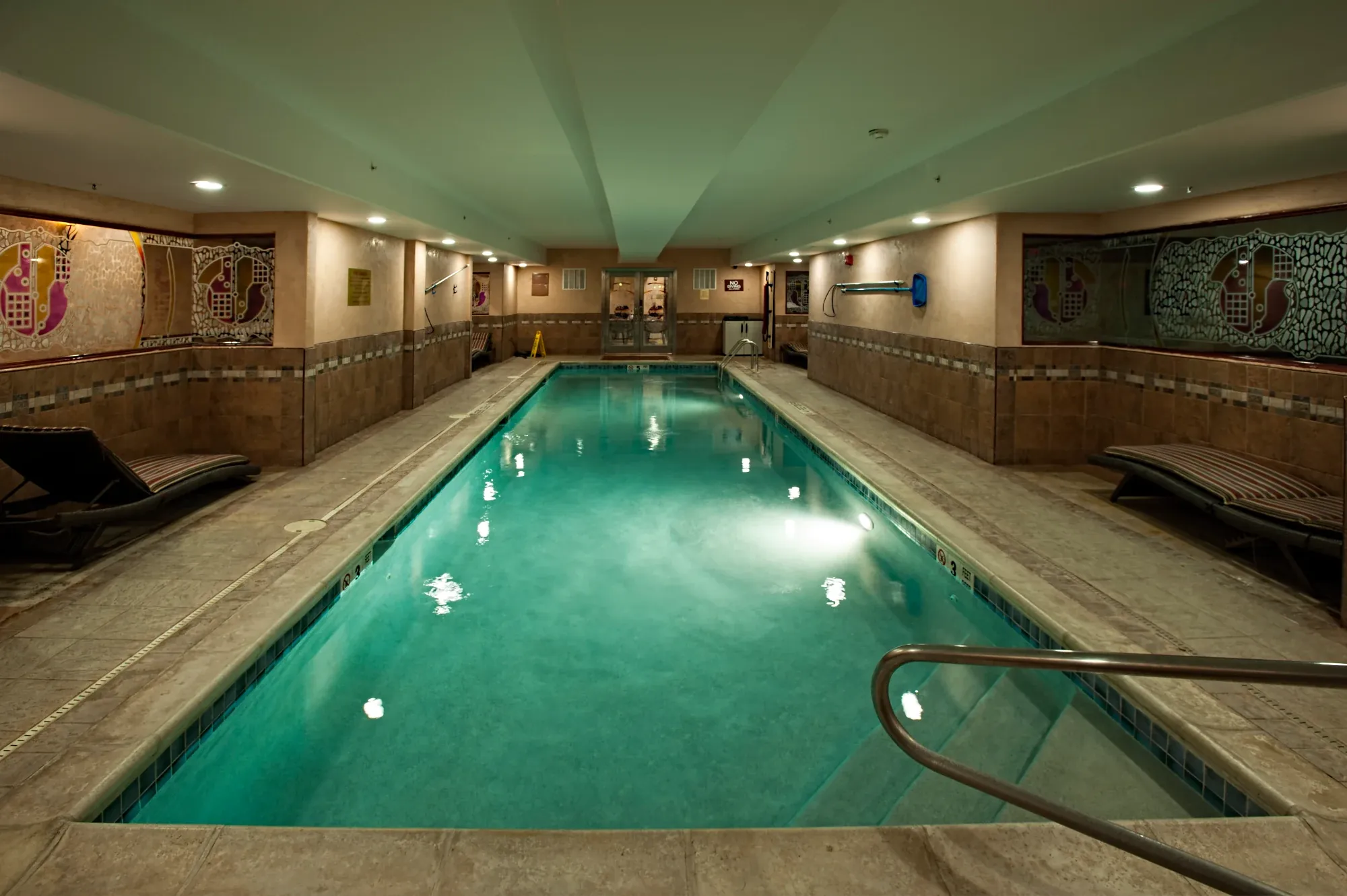 The length of BRC's Junior Olympic lap pool under a low ceiling, lights on the water.